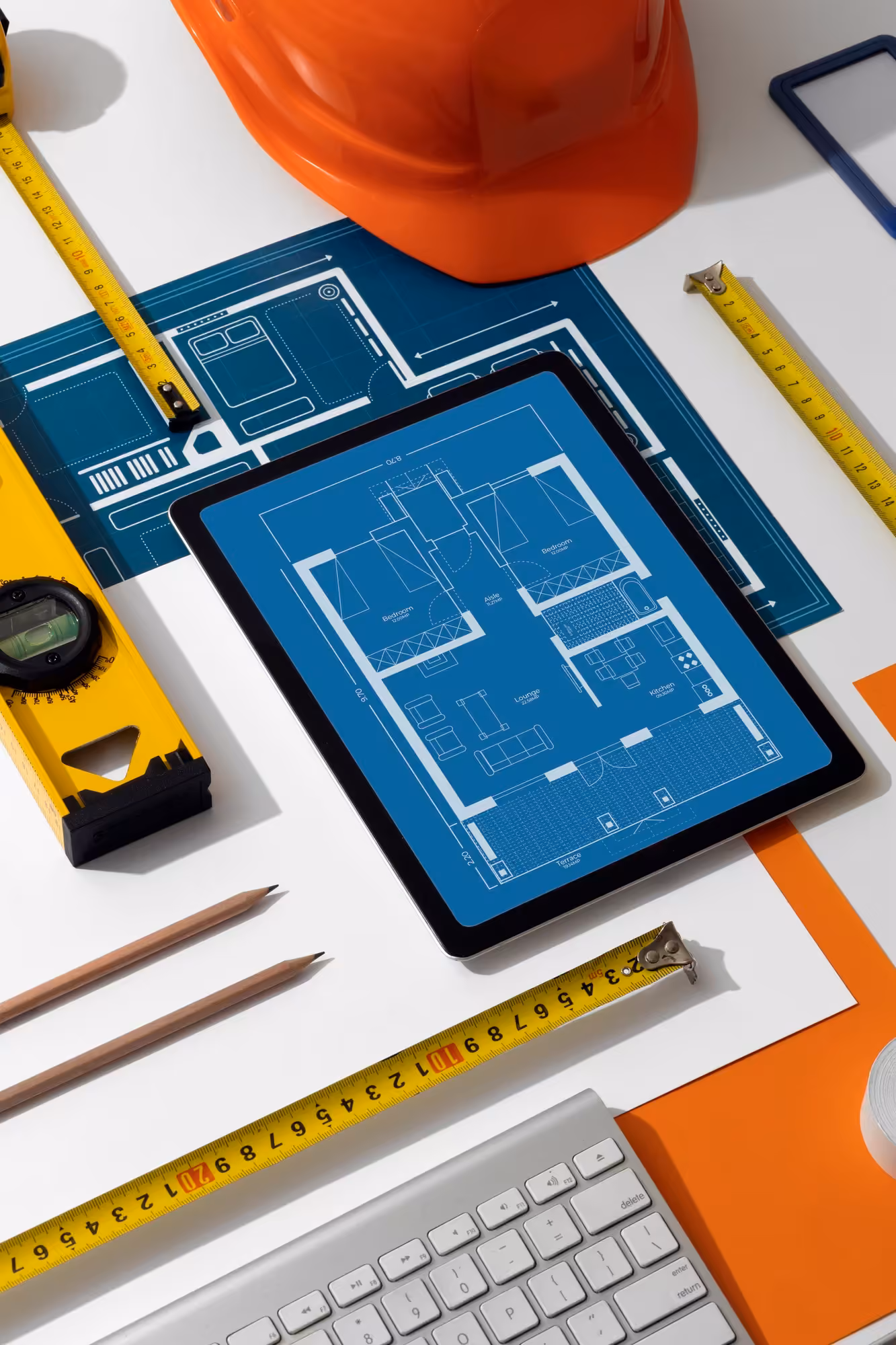 Blueprints and digital tablet with construction plans.